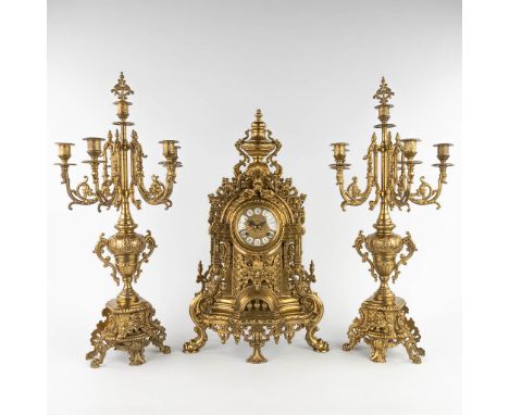 A three-piece mantle garniture clock, bronze, clock and candelaba. 20th century.&nbsp;Height of the candelabra: 68 cm.&nbsp;(