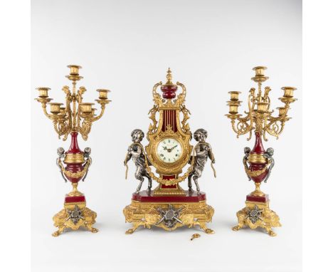 A three-piece mantle garniture clock and candelabra, Empire style, circa 1970.&nbsp;Height of the candelabra: 60 cm.&nbsp;(L:
