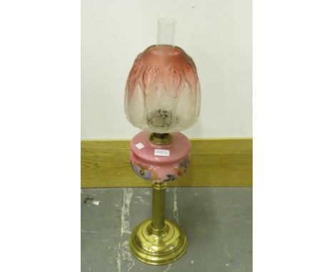 A BRASS REEDED OIL LAMP WITH PAINTED PINK SHADED GLASS FOUNT, BRASS BURNER AND PINK ETCHED RESERVOIR