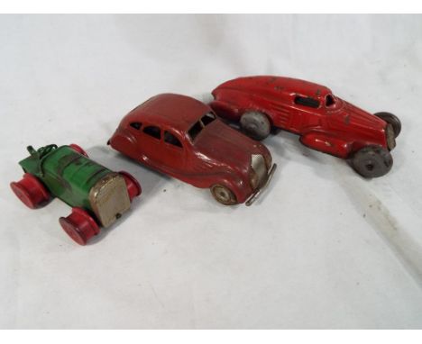 An early period Japanese clockwork airflow / streamlined red car, a Minic clockwork tractor, green with red wheels (driver's 