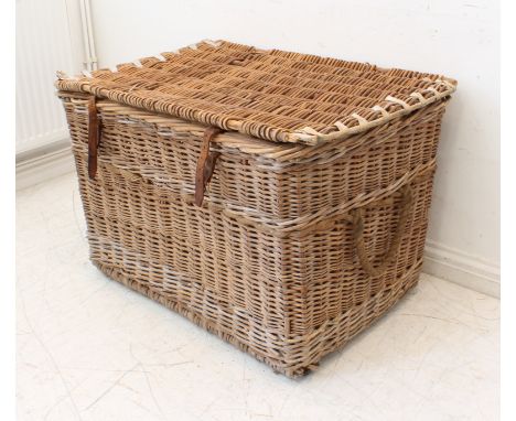 A large early 20th century wicker trunk with leather securing straps and two rope handles (LWH 96 x 66 x 57 cm).