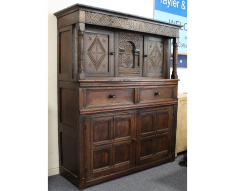 A late 17th century oak court cupboard: the outset cornice above a frieze centrally carved with the initials 'I T M' and date