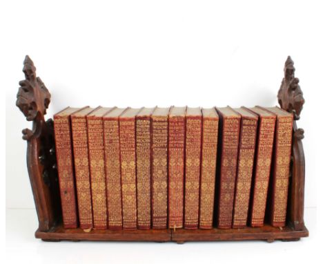 A Victorian carved oak Gothic Revival extending tabletop bookshelf - the shelf holding fourteen gilt red morocco bound 'Every