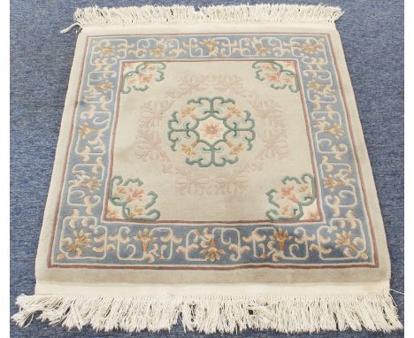 Two Chinese woollen rugs: 1. a small and heavy rug with central mon against a beige ground, four flower-type spandrels and a 