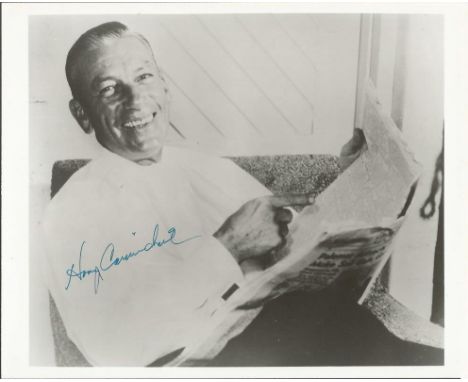 Hoagy Carmichael signed 10 x 8 vintage black and white photo image of him seated with paper in hand. Good condition. All sign
