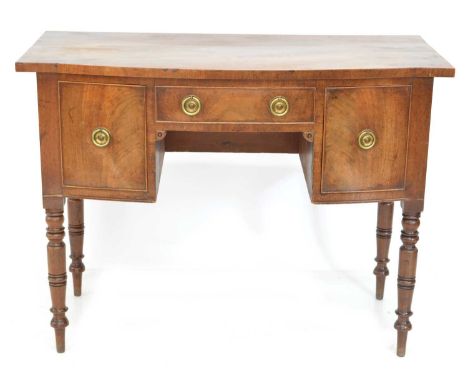 Early 19th-century mahogany cabinet or dressing table, bow front accommodating one shallow and two deep drawers, all standing