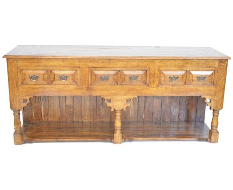 Late 20th-century oak dresser base of Jacobean design, planked top above three drawers with moulded decoration, each fitted w