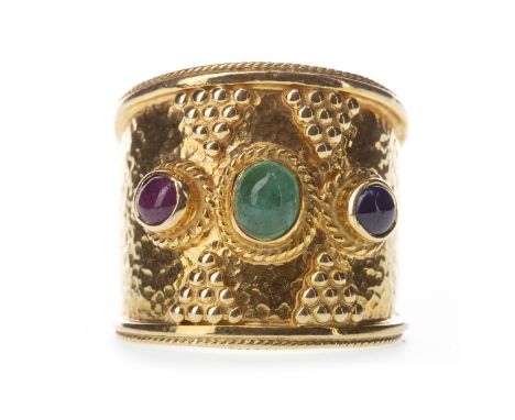 GEM SET THREE STONE RING, with central red, green and blue cabochon gems, each within a ropetwist border, interspaced by tria