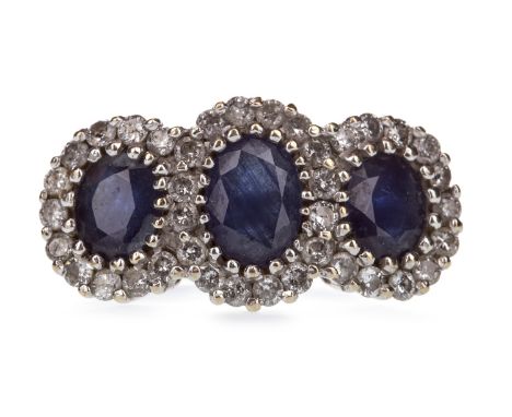 BLUE GEM SET AND DIAMOND CLUSTER RING, the three oval blue gems within a round brilliant cut diamond border, the diamonds tot