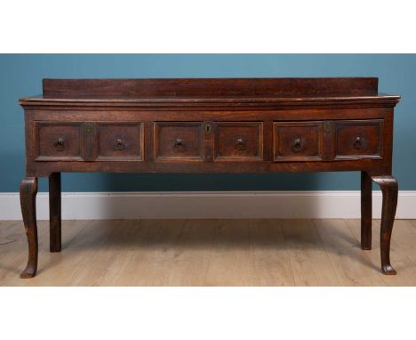 An 18th century mahogany dresser base with panelled drawers and ring handles, raised on cabriole legs and pad feet80cm high x