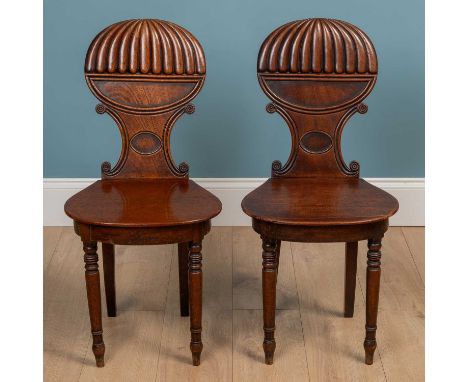 A pair of Regency style hall chairs, the C scrolled backs above a fitted panel seat raised on ring-turned legsQty: 2Some sign