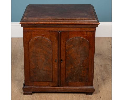 An early Victorian mahogany cabinet with twin panelled doors, revealing three drawers with inset brass ring handles53cm wide 