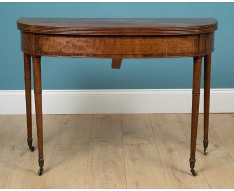 A Regency mahogany D-end fold-over console table with ebony banding to the frieze raised on ring turned legs and terminating 