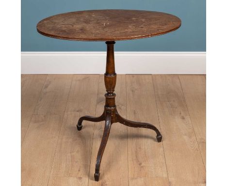 A George III oval tripod table with turned column support and the legs terminating in spade feet69cm wide x 47cm deep x 70.5c