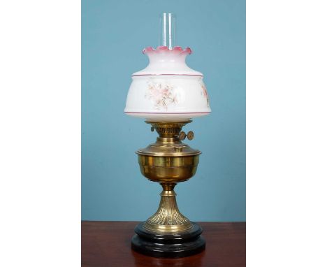A Victorian brass oil lamp, the opaque shade above a brass reservoir raised on out-splayed reeded support and a ceramic base5