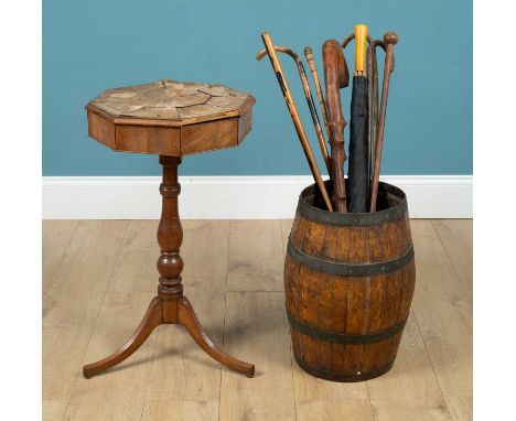 A brass bound stick stand modelled as a barrel, with seven walking sticks and an umbrella; together with a sewing box on stan