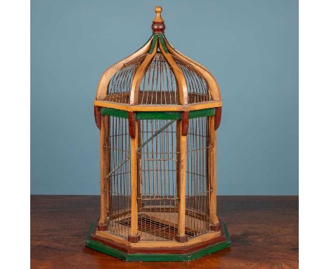 A wooden framed birdcage shaped as a pagoda with wirework bars, all topped by a wooden finial65cm highSome rubbing to the woo