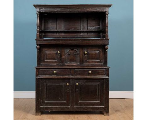 An 18th century Welsh oak tridarn, the upper storey with a shelf above two cupboard doors either side of an arcaded panel, wi