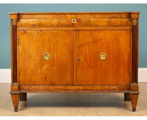 A small 19th century continental walnut side cabinet with outset pilaster columns flanking a frieze drawer and two cupboard d