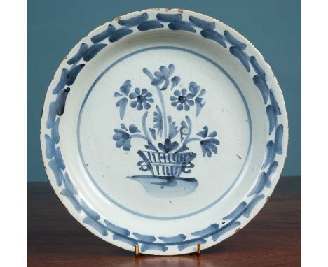 An 18th century English delftware plate centrally decorated with a basket of flowers22cm diameterMinor chips, marks and crack
