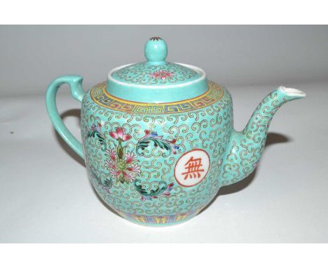 A Chinese porcelain teapot, late 19th Century, the turquoise ground with polychrome design of flowers and Chinese symbols