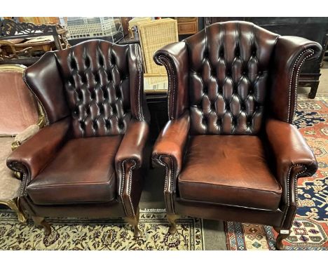 Two similar 20th Century leather button back Chesterfield type wing chairs raised on cabriole legs