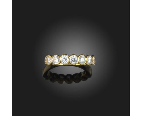 A diamond seven stone ring, the round brilliant-cut diamonds rubover-set in 18ct yellow gold, London hallmarks for 1990, size