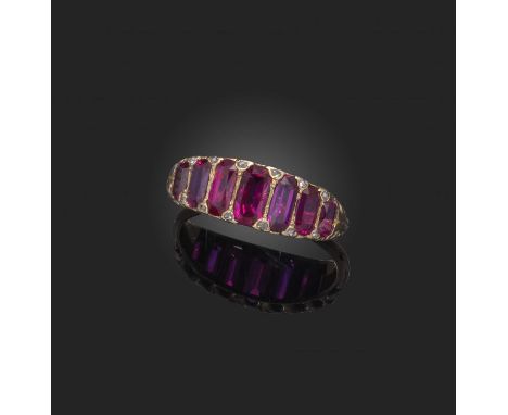 A ruby seven stone ring, the graduated step-cut rubies with diamond pointers set in pierced yellow gold setting, size QA verb