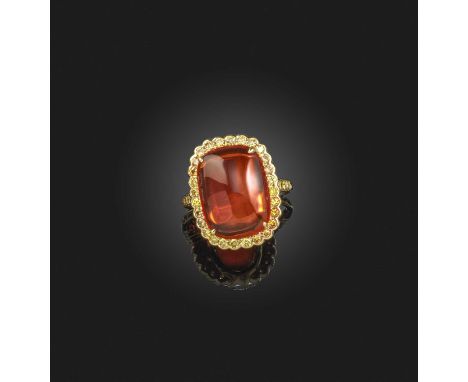 A fire opal and diamond cluster ring, set with a cushion-shaped fire opal within a surround of yellow diamonds in yellow gold