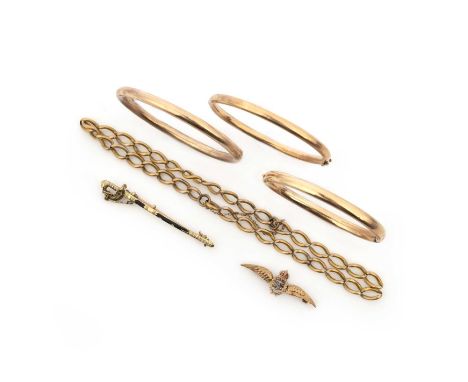 A collection of gold jewels, comprising: three gold bangles of hinged design, a gold and black enamel brooch designed as a sw