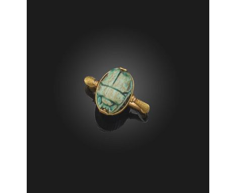 A faïence ring, mid-19th century, set with a faïence scarab bead, its reverse with a heiroglyphic inscription, in an exhibiti