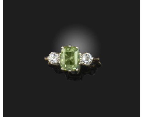A zircon and diamond ring, first half 20th century, set with a cushion-shaped green zircon, between shoulders set with circul