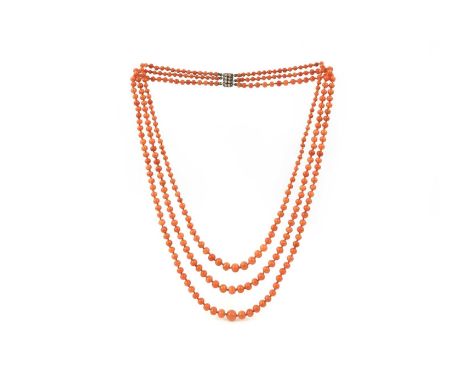 λ A coral and pearl necklace, late 19th/early 20th century, composed of three strands of graduated coral beads, to a clasp se