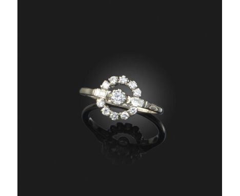A diamond cluster ring, set with a circular-cut diamond, baguette-shaped diamond shoulders and a further circular border of d