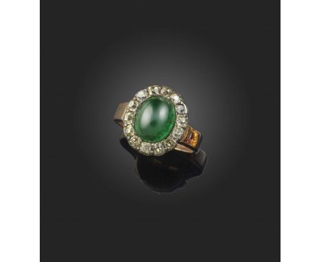 An unusual emerald and diamond ring, late 19th century, of cluster design, set with a cabochon emerald within a border of cus