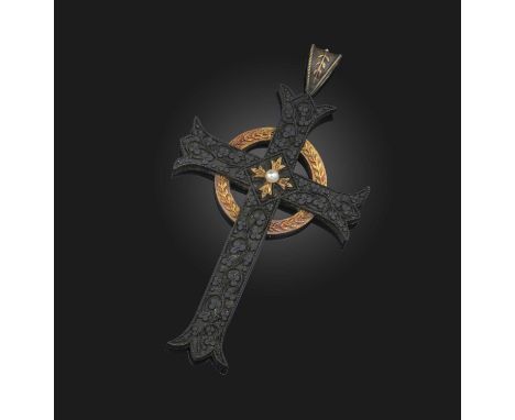 A mid 19th century Irish bog-oak cruciform pendant, intricately carved with shamrocks and with a gilded wreath and a central 