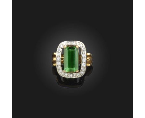 A tourmaline and diamond ring, claw-set with a step-cut green tourmaline, within a border of brilliant-cut diamonds, mounted 