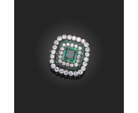 An emerald and diamond brooch, early 20th century, of rectangular outline with rounded corners, centring on a step-cut emeral