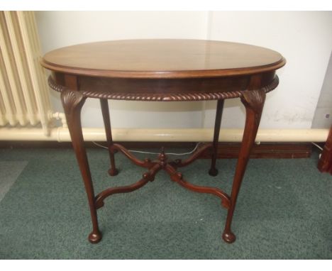 Mahogany oval form centre table, raised stretcher with central finial, gadrooned apron, tapered legs on pad feet, shell carvi