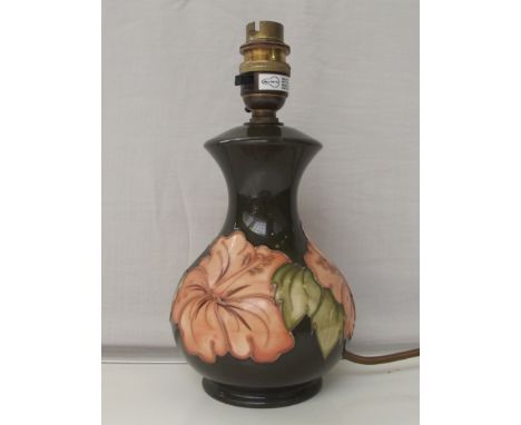 Moorcroft pottery table lamp tube lined in the Coral Hibiscus pattern against a green ground, impressed marks, 23cm in height