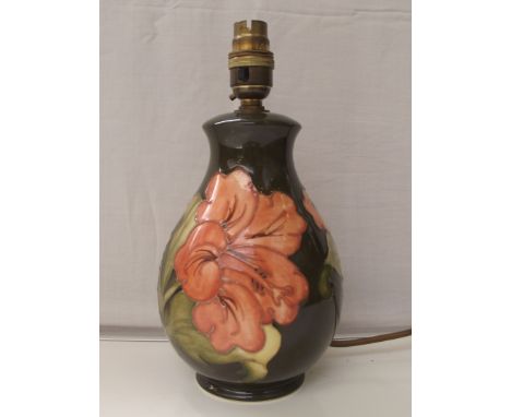 Moorcroft pottery table lamp, tube lined in the Coral Hibiscus pattern against a green ground, impressed marks, 26cm in heigh