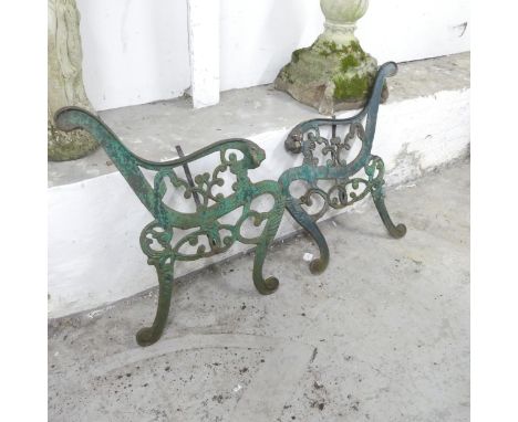 A pair of painted cast iron bench ends, with leopard head terminals. Height 74cm. 