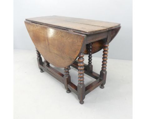 An antique oak oval gate-leg table, with bobbin turned legs. 106x73x43cm (opening to 125cm).Top is loose. Various use related