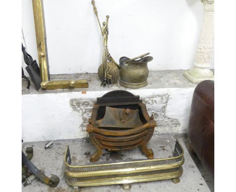 A cast iron fire grate, a brass fender, 81x22x23cm, a brass coal scuttle and a companion set. 