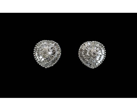 Pair of Diamond Cluster Earrings, a raised centre of round cut diamonds, closely framed with two rows of baguette cut diamond