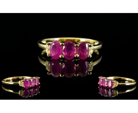 Ruby and White Topaz Ring, a trio of oval cut rubies, accented with small, round white topaz, totalling 1.75cts, set in gold 