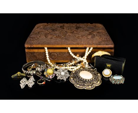 A Carved Wooden Box Containing A quantity Of Costume Jewellery Items A varied collection to include pewter tone snake bangle,