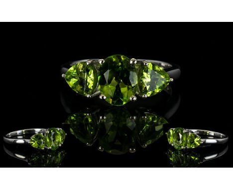 Peridot Three Stone Ring, a 2ct oval cut central peridot, flanked by two trillion cut similar stones of just under 1ct each, 