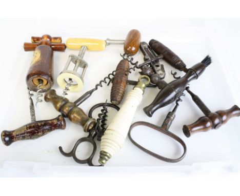 A collection of antique corkscrews and bottle openers together with a ceramic toilet pull handle.