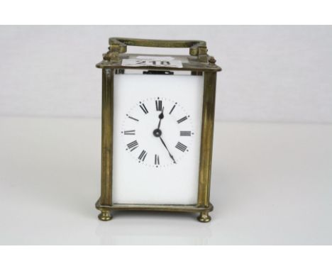 A brass cased carriage clock with white enamel dial.